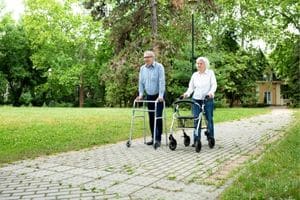 Man en vrouw buiten met looprek en rollator
